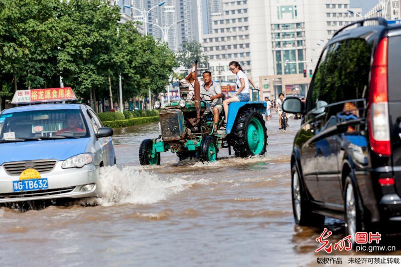 河南新乡暴雨:街道积水半米 拖拉机任性载人(1
