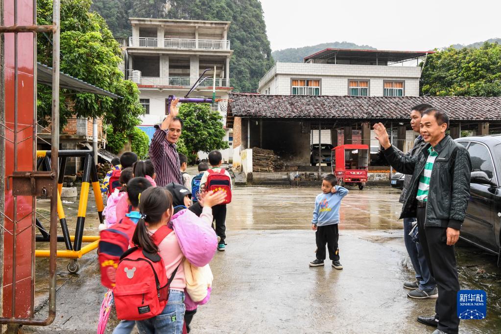 11月2日,在巷口村巷口小学,放学时许思红(左)与学生们告别.