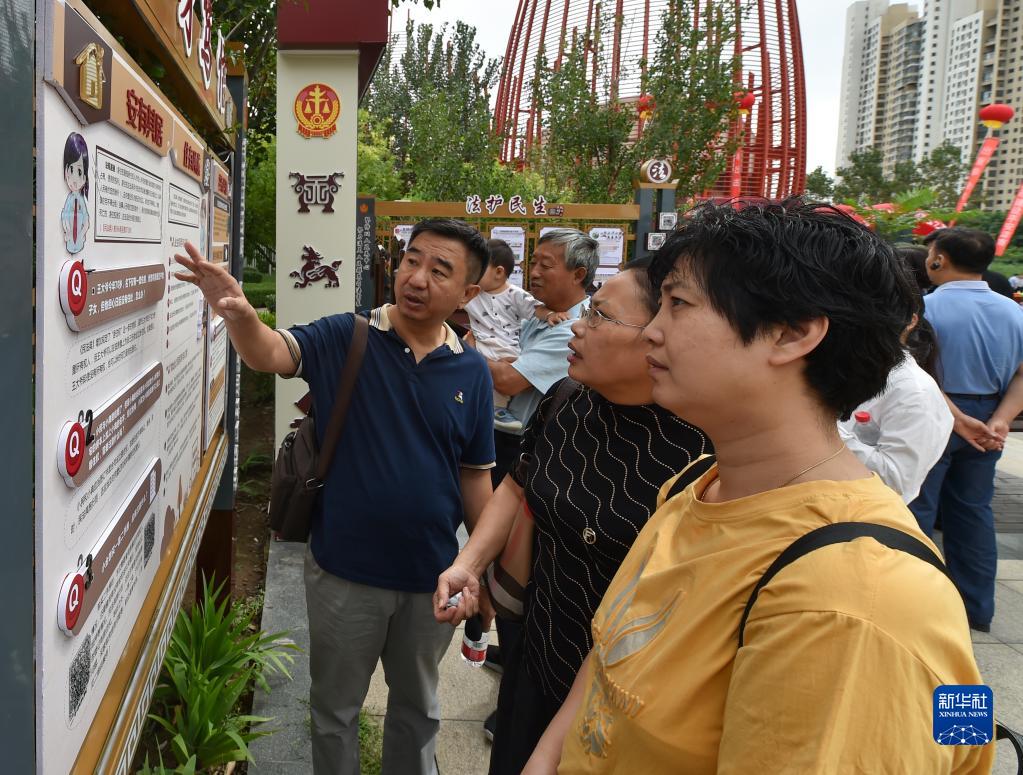 在天津市津南区海河故道公园民法典主题长廊，市民在讨论主题长廊展板上的法律案例(2020年8月20日摄)。新华社记者 孙凡越 摄