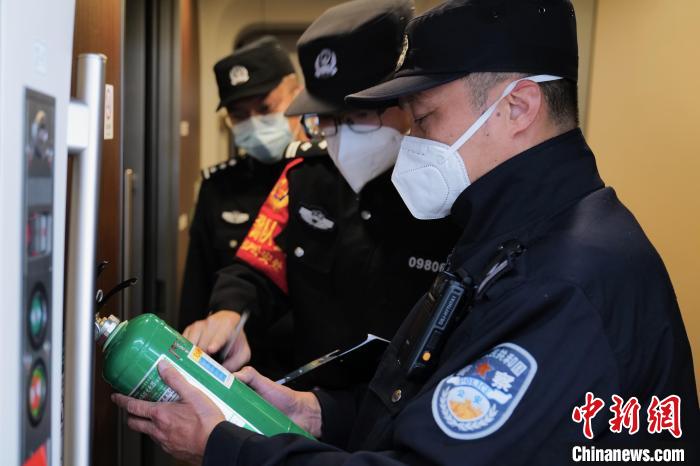 图为王聪在G320次列车始发前检查车厢消防设备。　陈文 摄