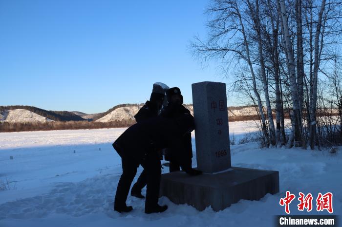 图为恩和哈达边境派出所的民警们清理界碑上的积雪。　牟东印 摄