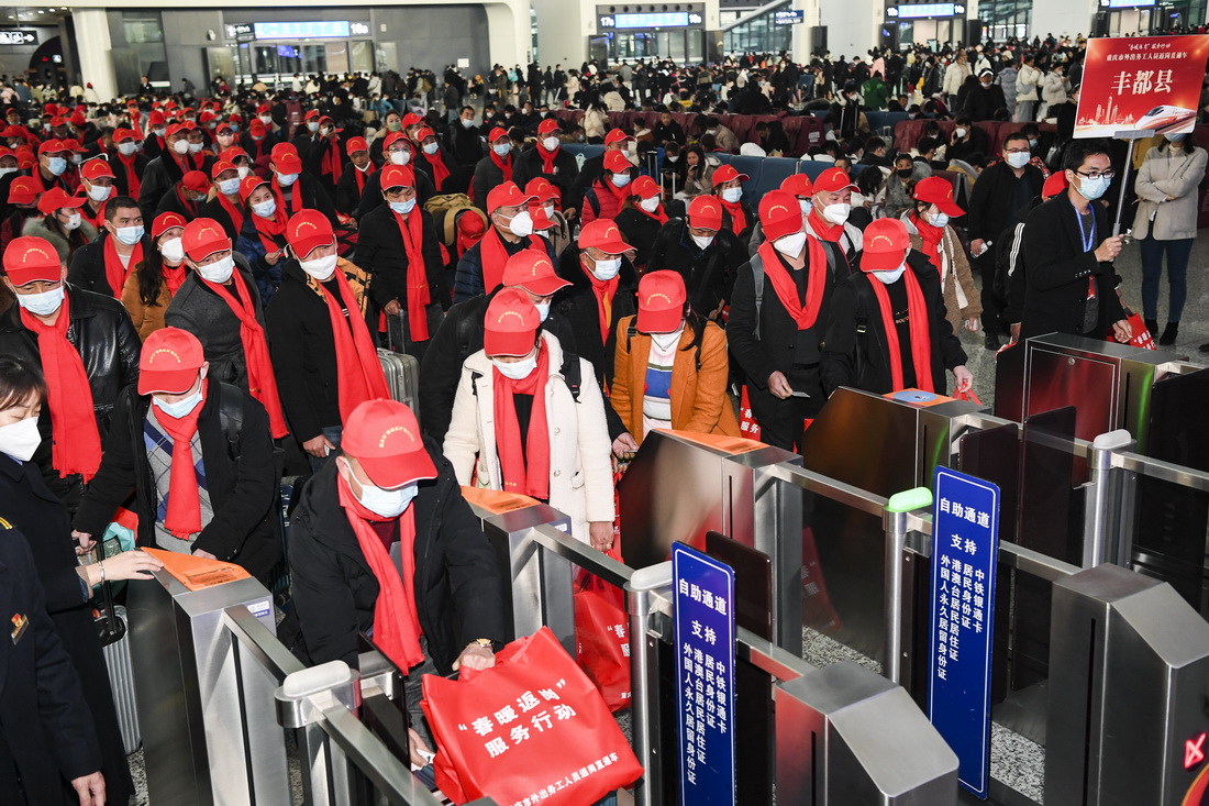 1月30日，在重庆西站，乘坐2023年重庆首趟务工定制专列的旅客自助检票，前往站台乘车。