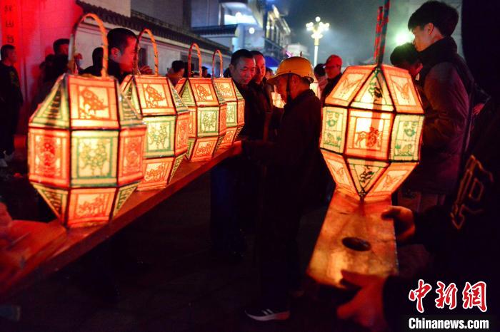 图为村民正在将各家龙灯接驳在一起，成为一条完整的龙灯。　张斌 摄