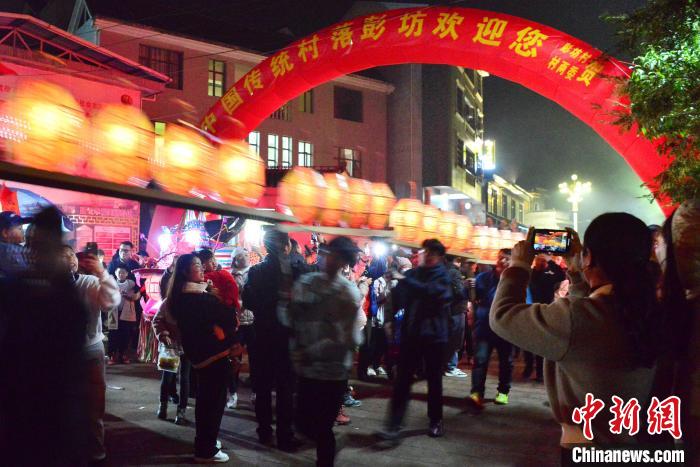 图为刻纸龙灯巡游吸引了许多民众前来观赏。　张斌 摄