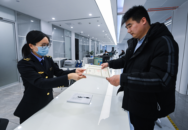 2023年2月8日，浙江省湖州市吴兴区，企业负责人在中小微企业一站式服务平台领取营业执照。