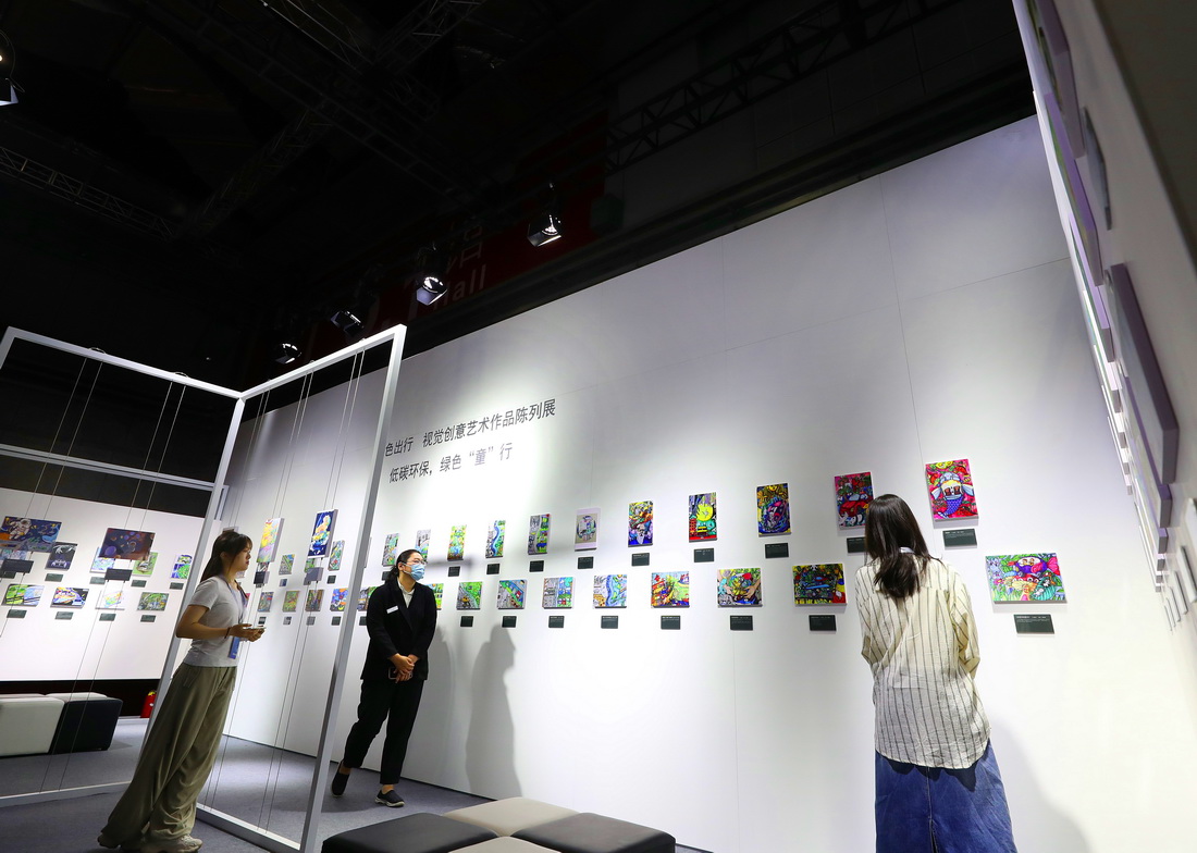 首届上海国际碳中和博览会在沪开幕 6月11日,参观者在博览会上一个低碳环保主题儿童绘画作品展示区内驻足观看。