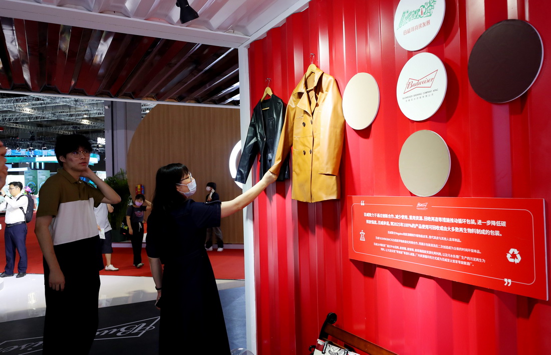 首届上海国际碳中和博览会在沪开幕 6月11日,参观者在博览会现场用手触摸一件使用废酒糟为原料制作的植物基皮革服装。