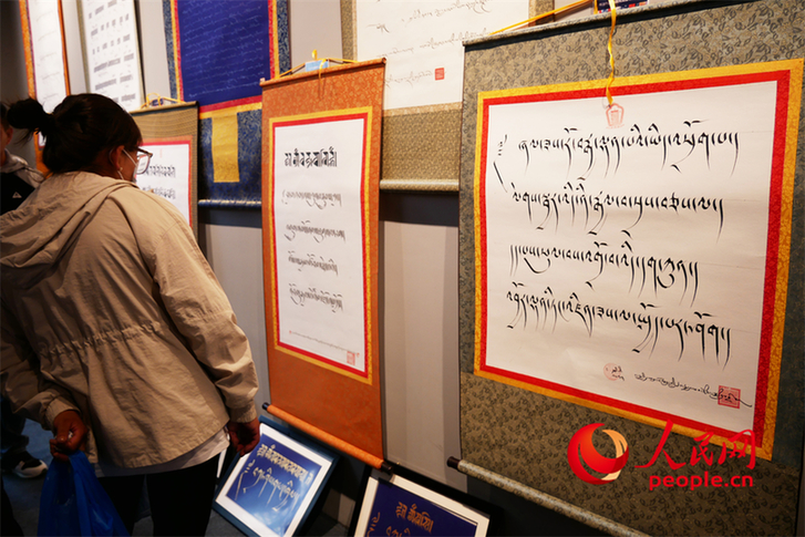 观众正在欣赏展出的藏文书法作品人民网 韦衍行摄