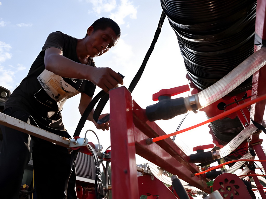 河北涿州:加快灾后复耕补种 8月18日,在涿州市刁窝镇潘各庄村,工作人员为播种机安装滴灌带。