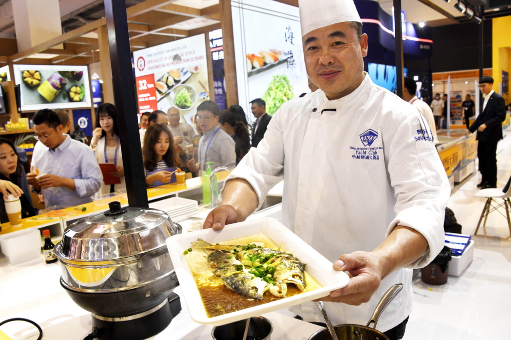 第26届中国国际渔业博览会在青岛开幕 10月25日,参展企业的厨师在渔业博览会上加工水产品。