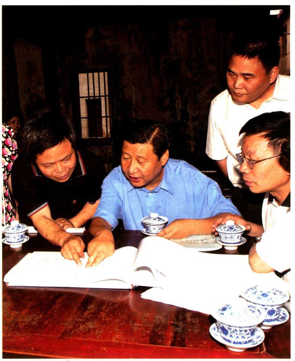 2006年6月，时任浙江省委书记的习近平在金华市磐安县玉山镇考察古茶场，查看建设图纸。