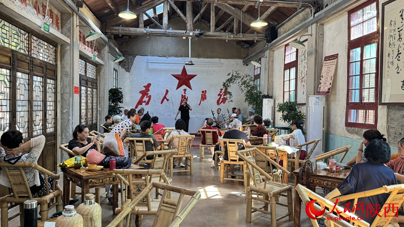 行进中国丨从“幸福园”到“幸福城” 汉台区“爱转角”非遗文创街区的老茶馆里,市民正在欣赏秦腔表演。人民网记者 李志强摄